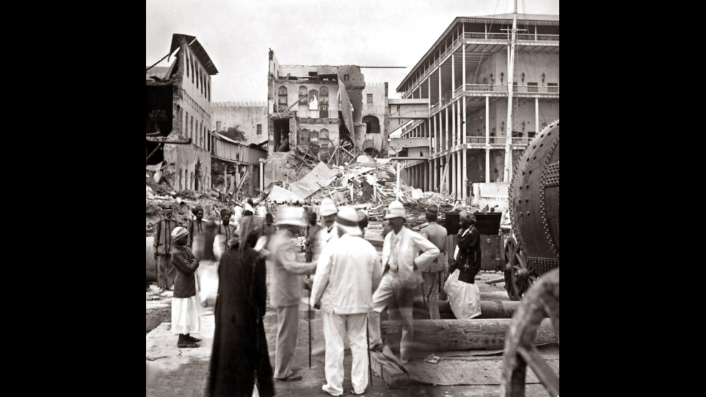 British officers in white uniforms and pith helmets standing among ruins in Zanzibar